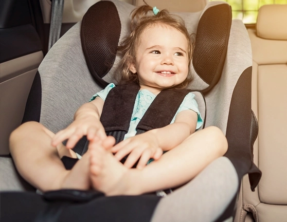 Bebé sentado en una silla de seguridad infantil dentro de un coche
